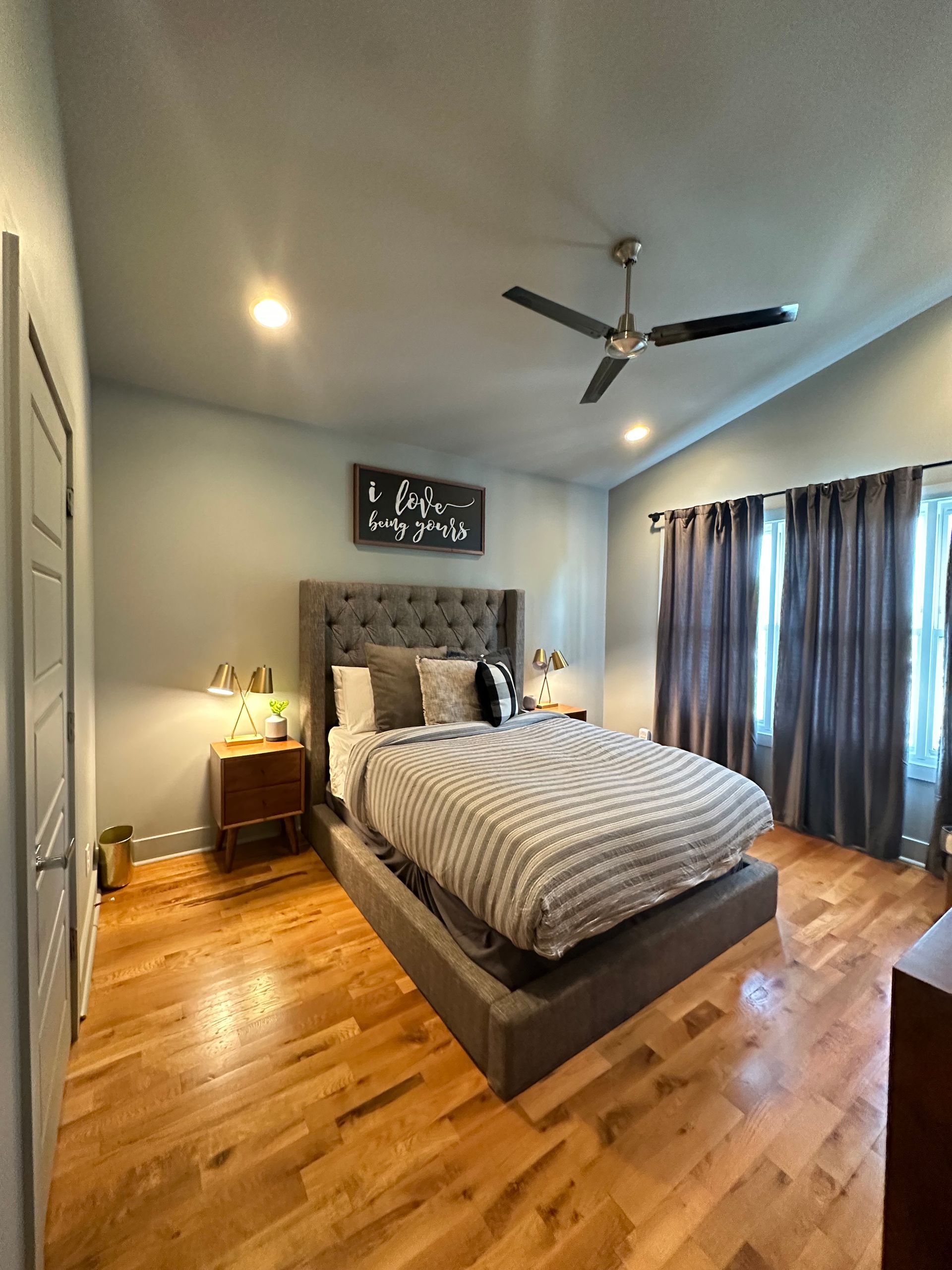 A bedroom with a large bed and a ceiling fan