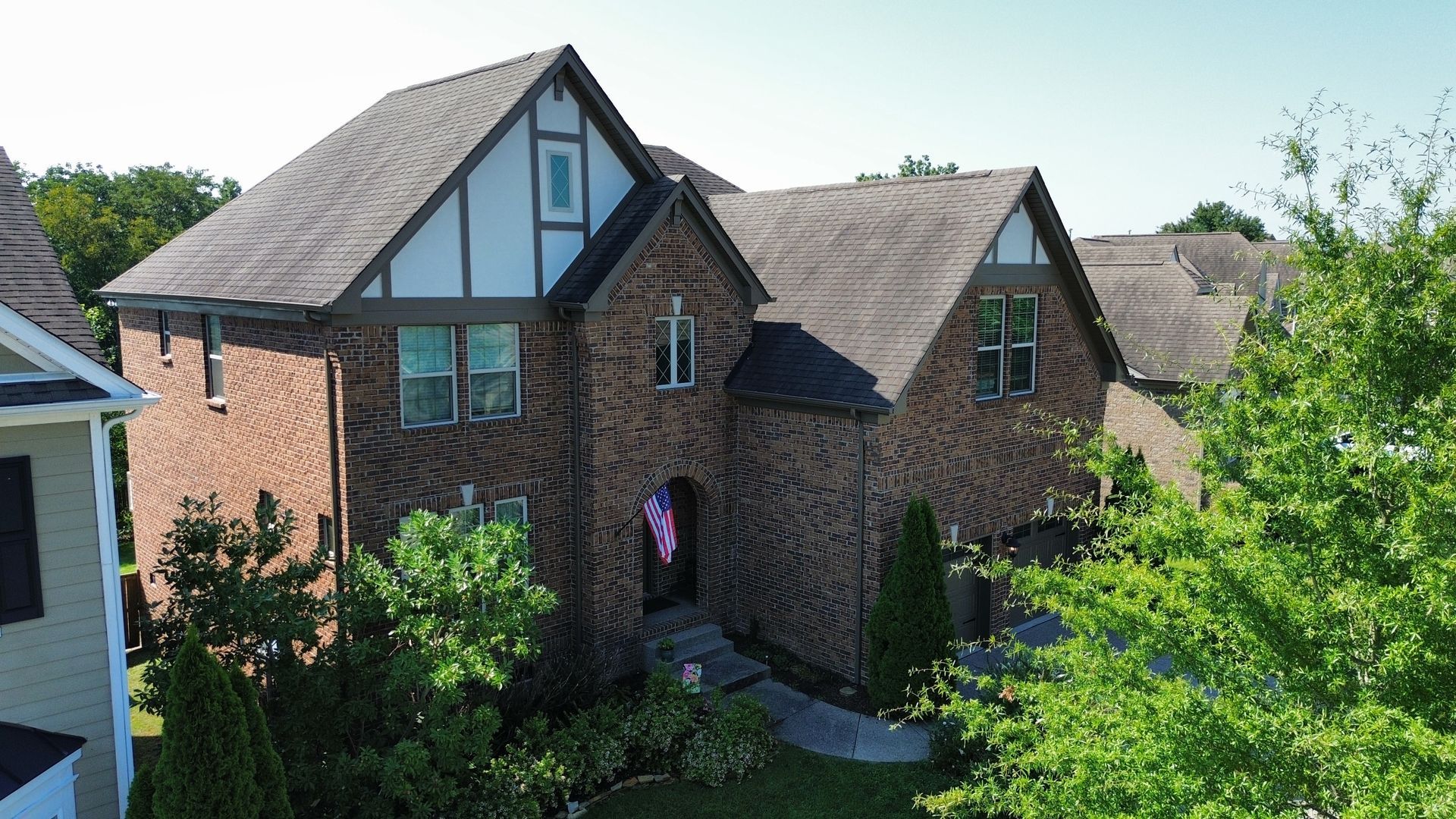 An aerial view of a large brick house with a black roof in Nashville, TN