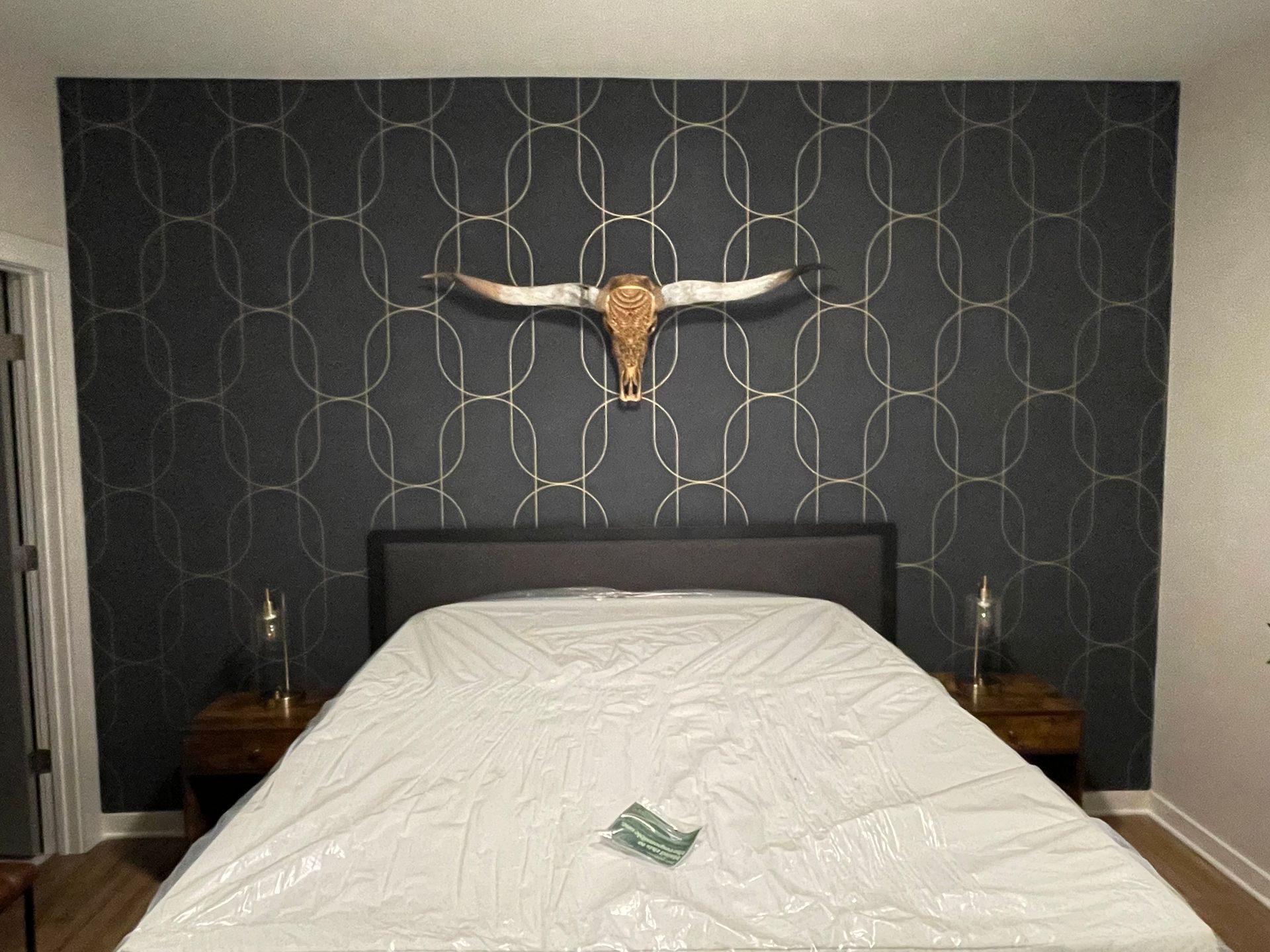 A bed with a longhorn skull hanging above it in Nashville, TN