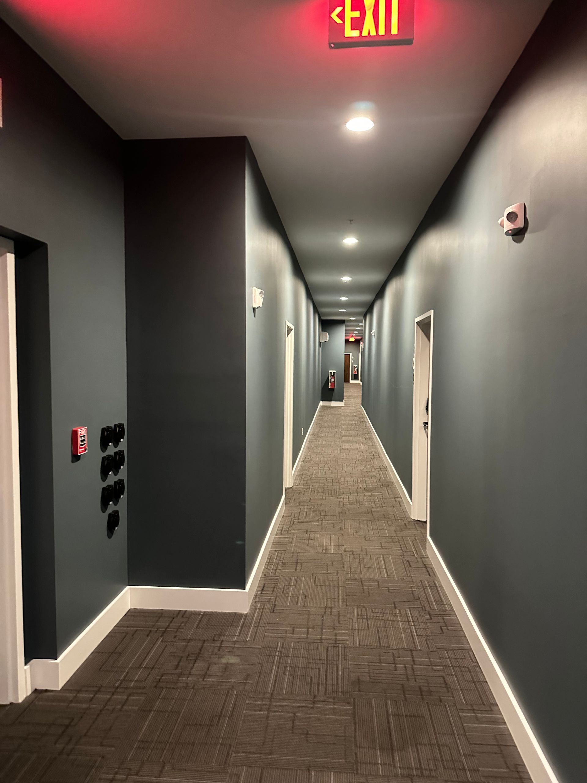 A long hallway with a red exit sign above it in Nashville, TN