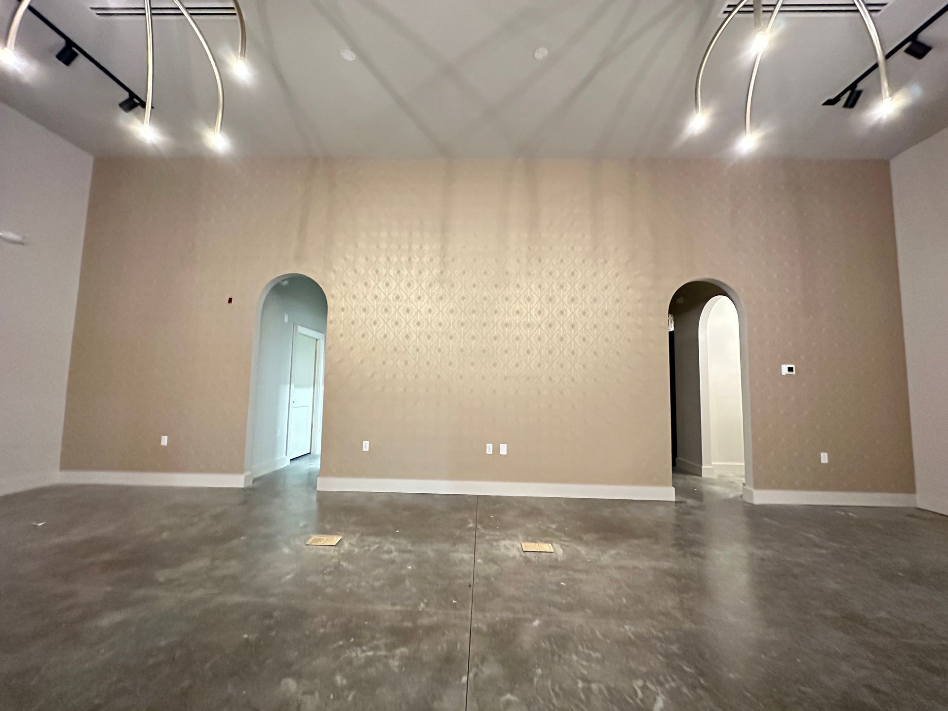 A large empty room with a concrete floor and arched doors in Nashville, TN