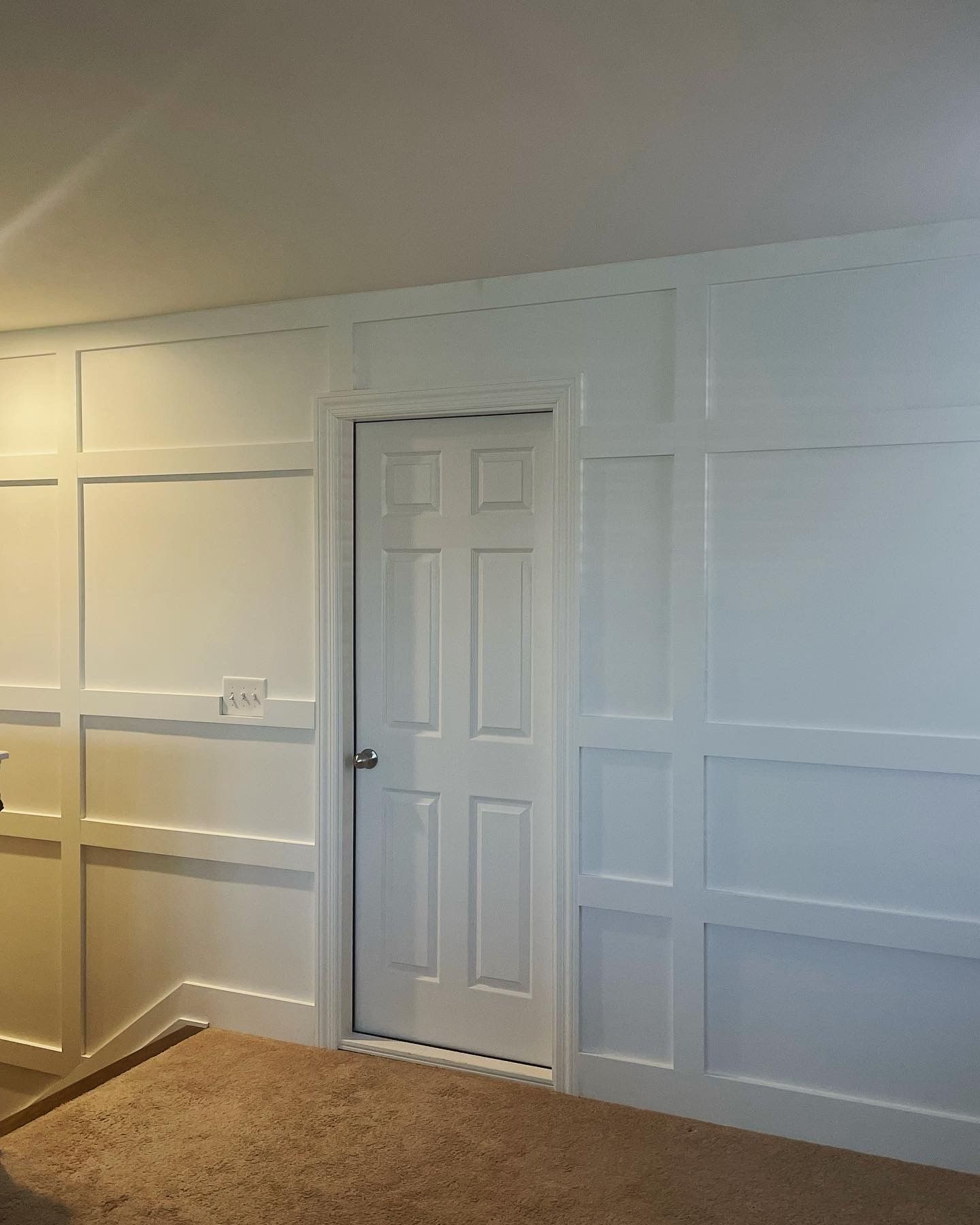 A room with white paneling and a door in Nashville, TN