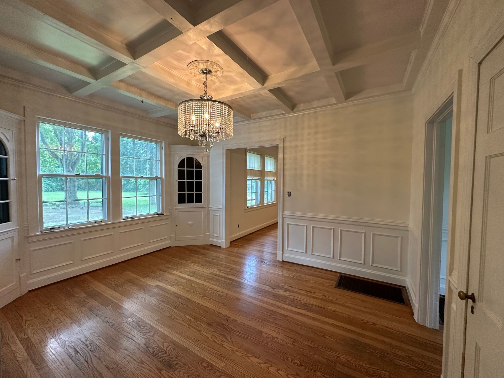 An empty room with hardwood floors and a chandelier hanging from the ceiling in Nashville, TN
