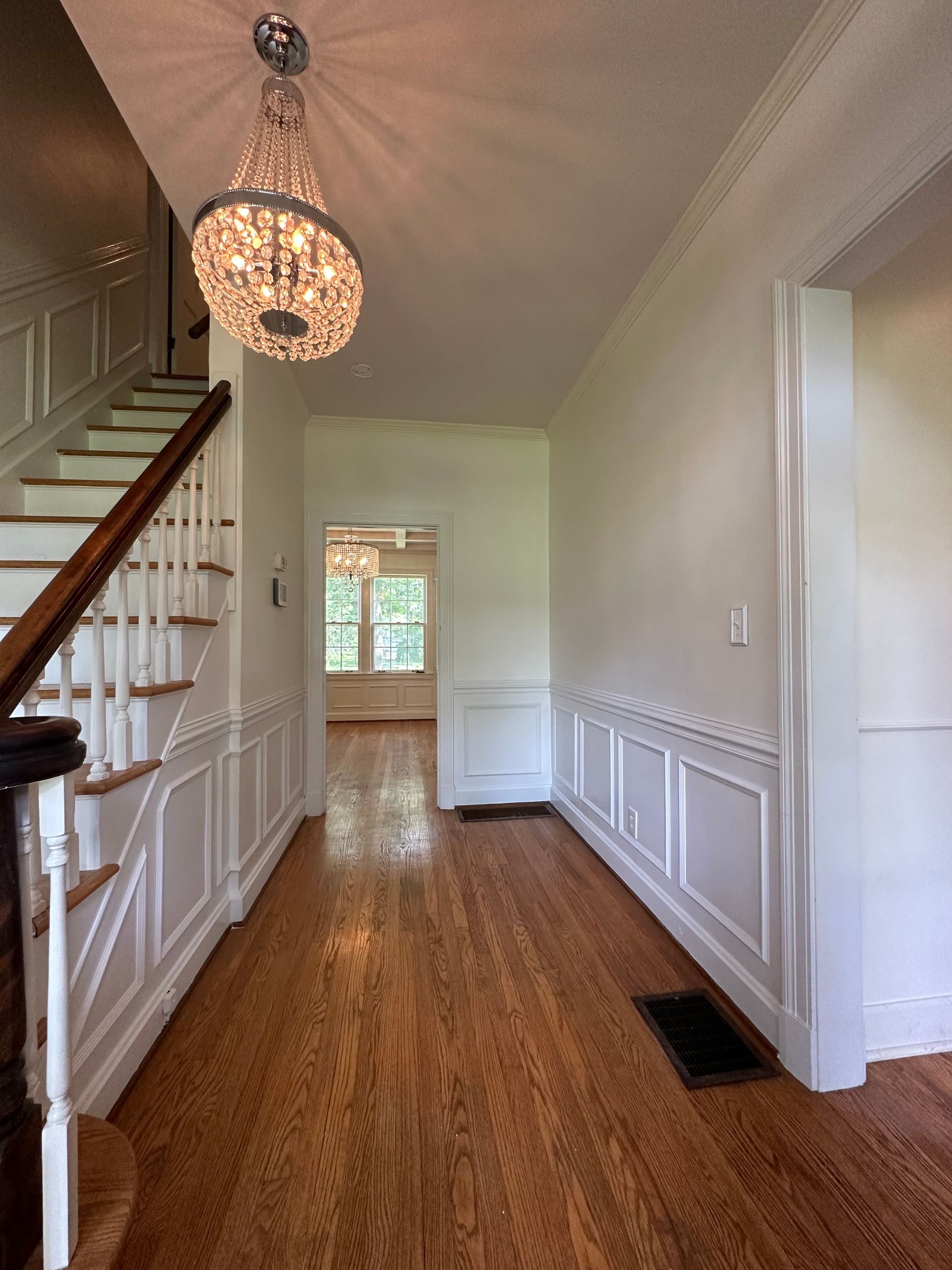 A hallway with stairs and a chandelier hanging from the ceiling in Nashville, TN