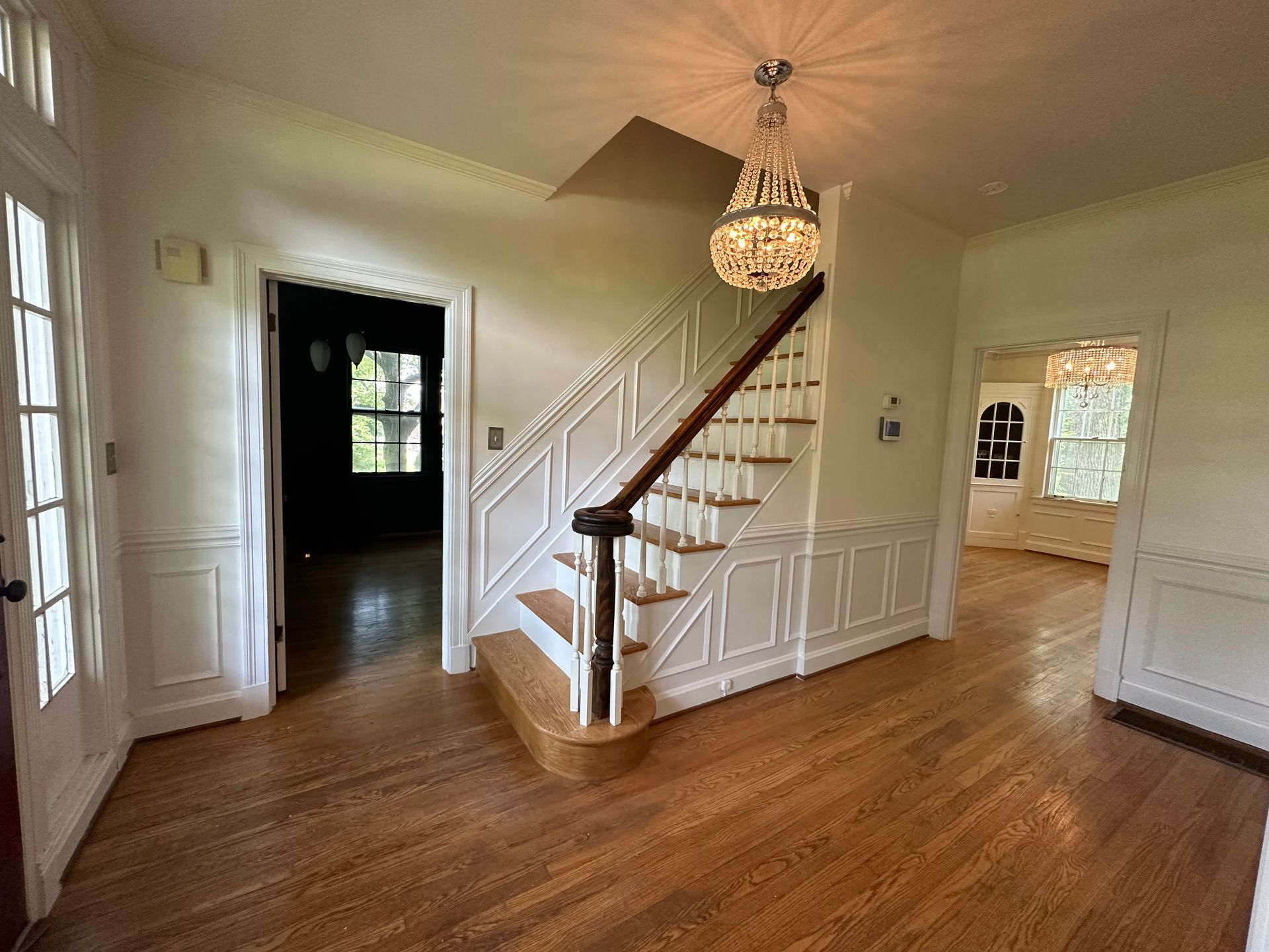 A hallway with stairs and a chandelier in a house in Nashville, TN