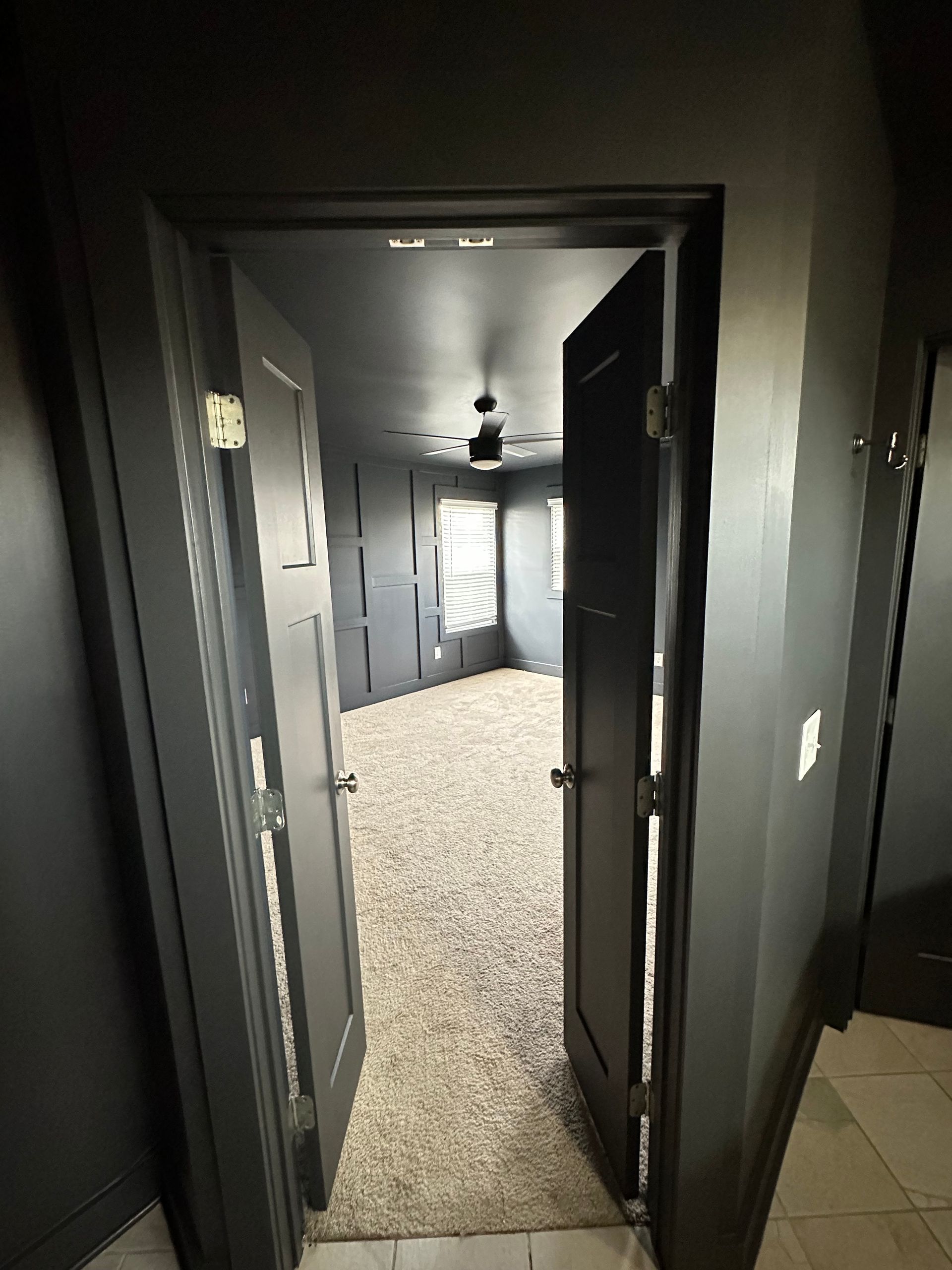 The door is open to a room with a ceiling fan