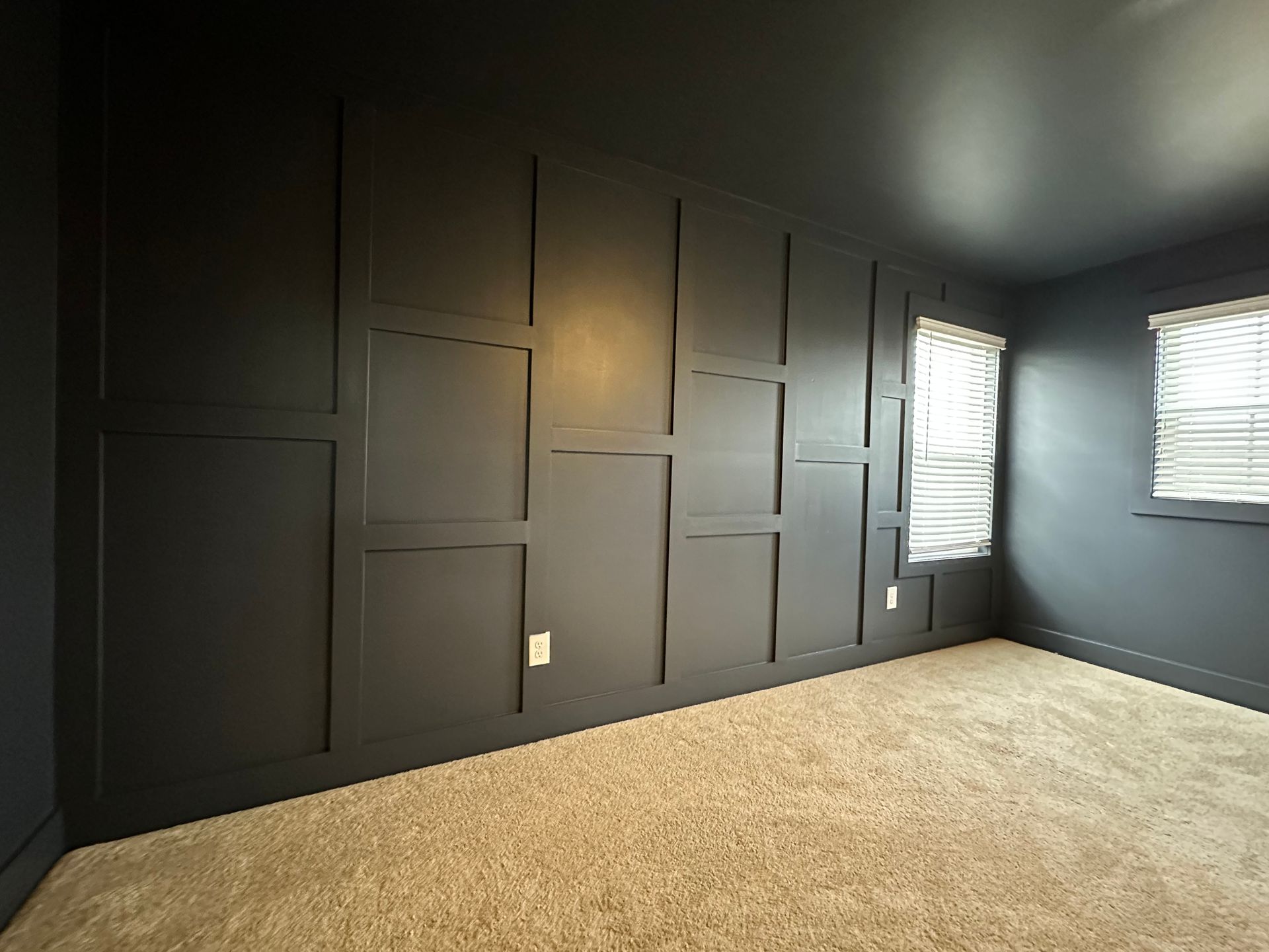 An empty room with black walls and a carpeted floor in Nashville, TN