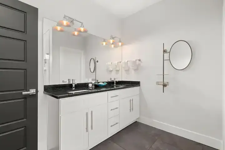 A bathroom with two sinks and a large mirror.