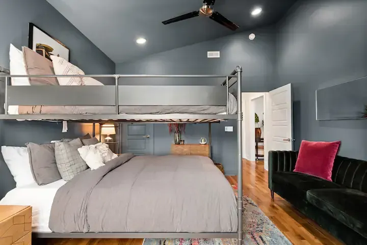 A bedroom with a bunk bed and a couch.