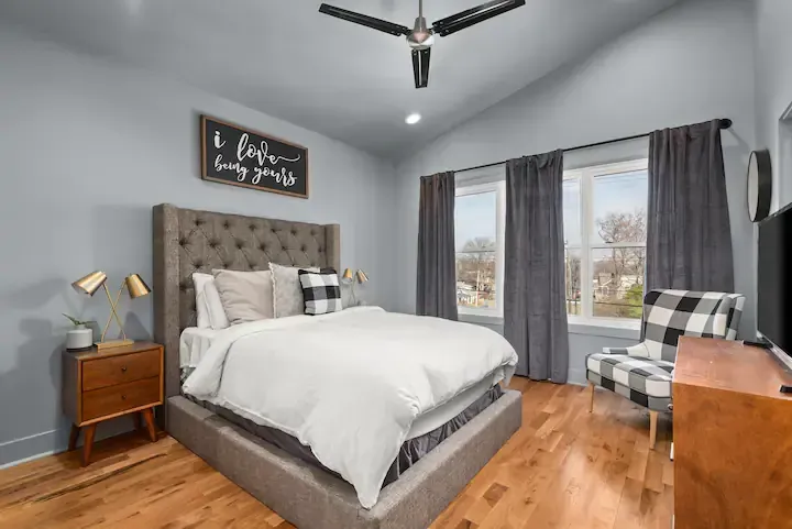 A bedroom with a bed , chair , nightstand and ceiling fan in Nashville, TN