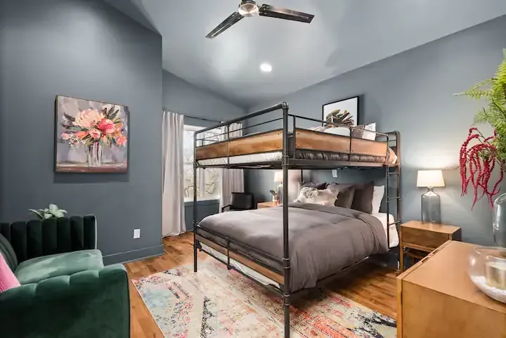 A bedroom with a bunk bed and a couch.