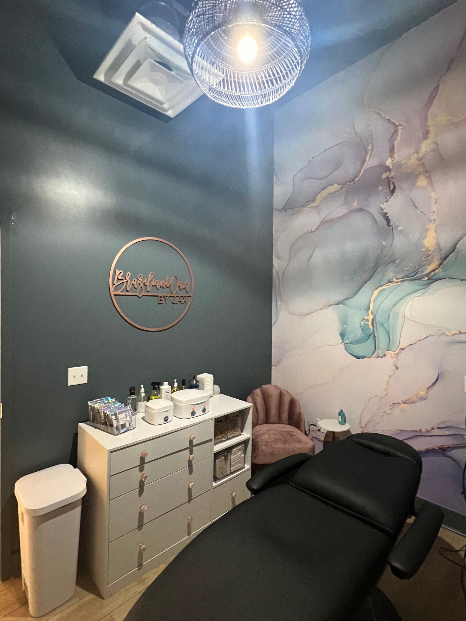 A room with a bed , dresser , chair and trash cans in Nashville, TN