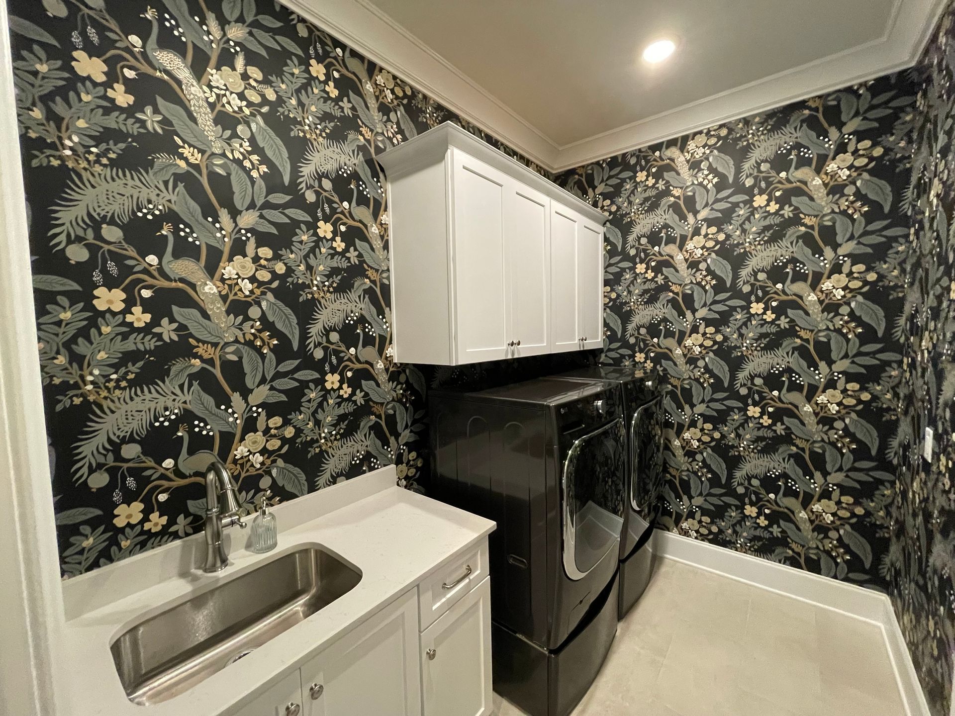 A laundry room with a sink , washer and dryer , and floral wallpaper in Nashville, TN
