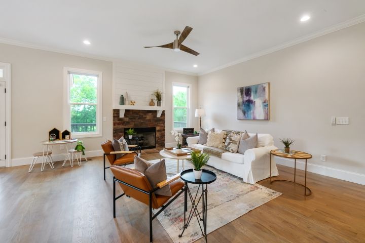 A living room with a couch , chairs , tables and a fireplace.