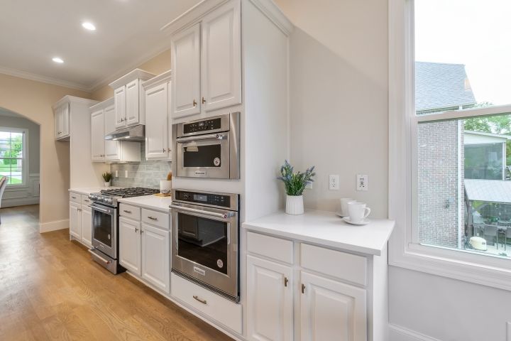 A kitchen with white cabinets and stainless steel appliances.