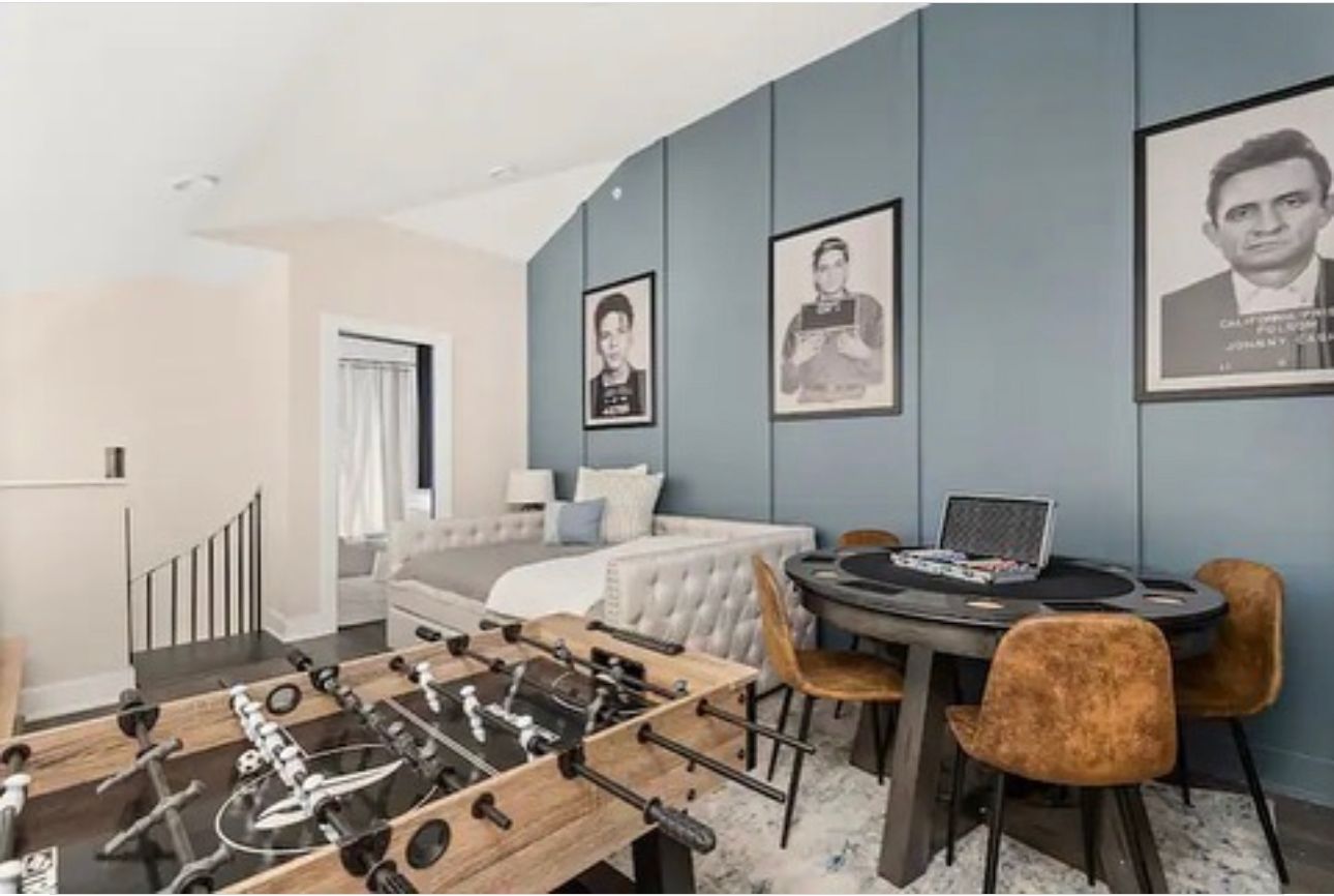 A room with a table and chairs and a foosball table in Nashville, TN