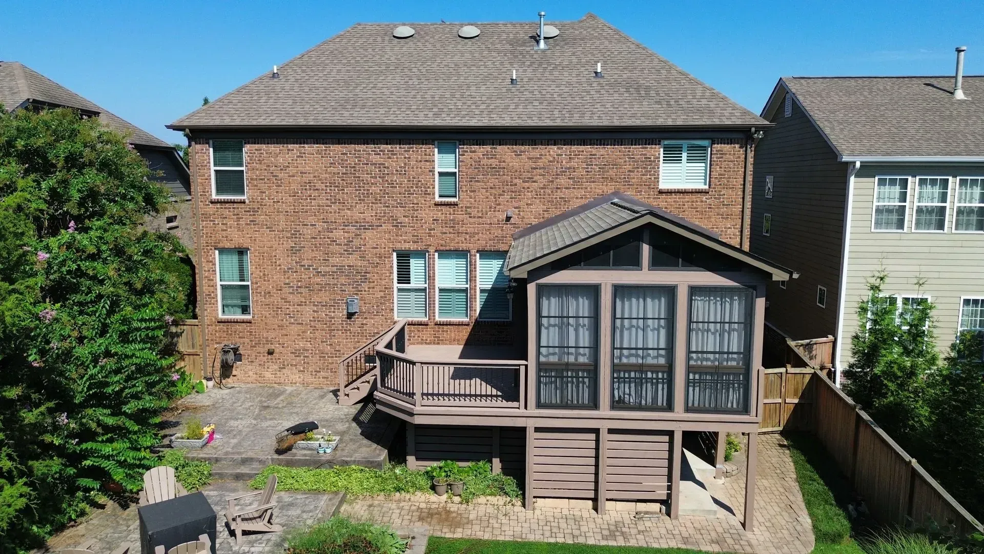 An aerial view of a brick house with a screened in porch in Nashville, TN