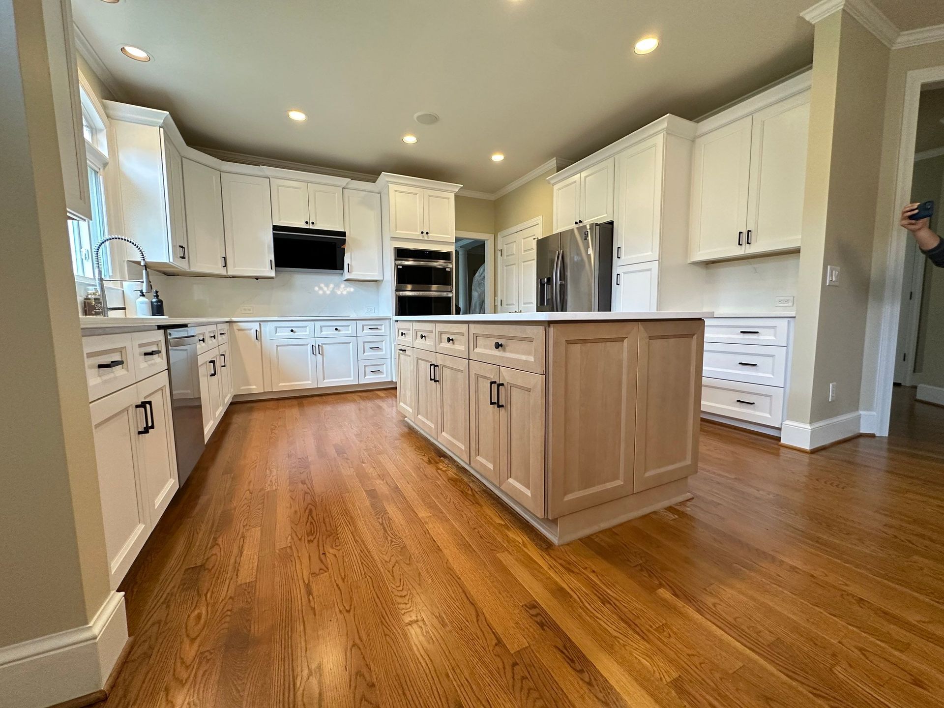 A bathroom with two sinks , a toilet , and a window.