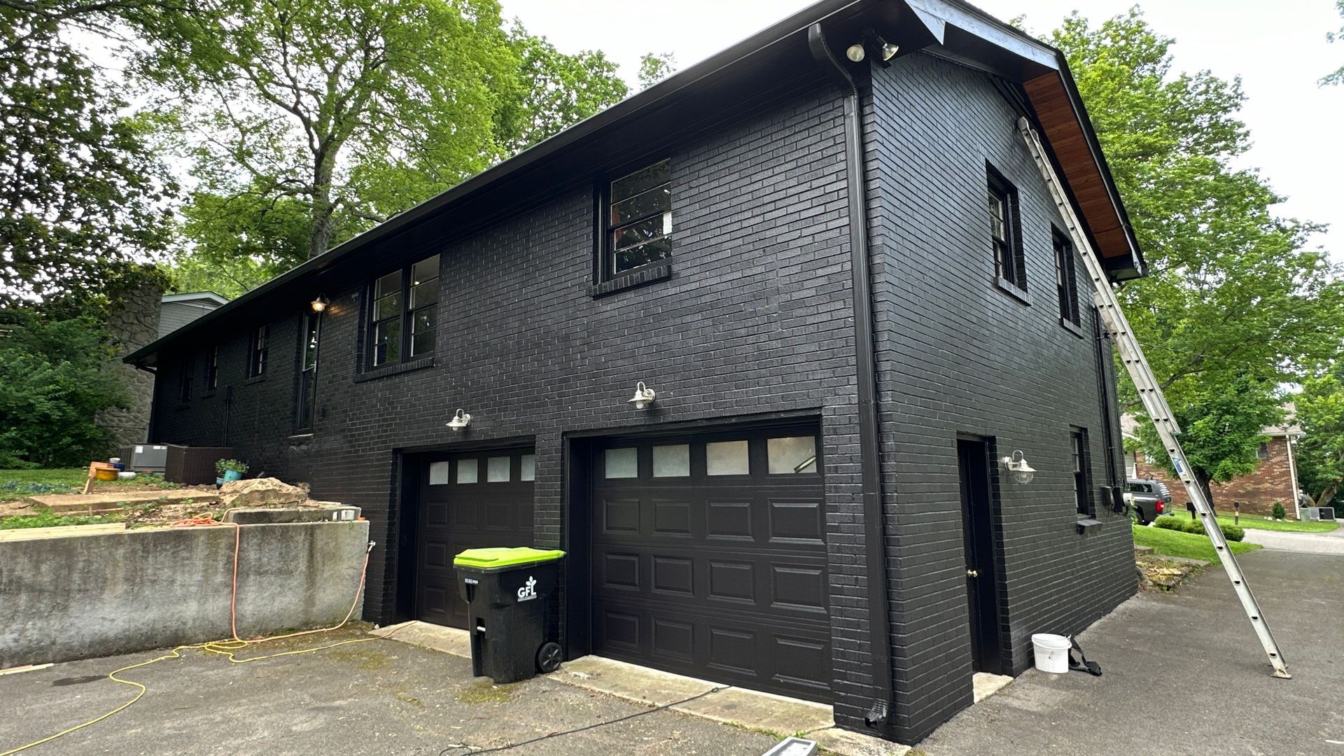 A black house with a garage and a ladder in front of it in Nashville, TN