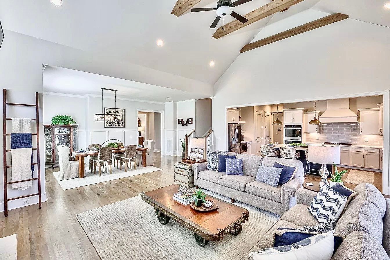 A living room with a couch , coffee table , and ceiling fan.