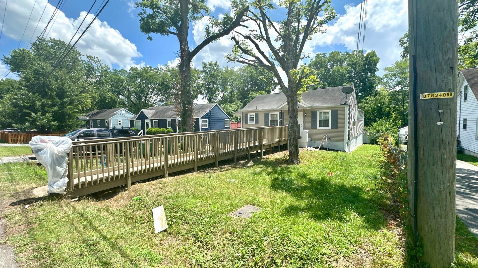 There is a wooden deck in the backyard of a house.