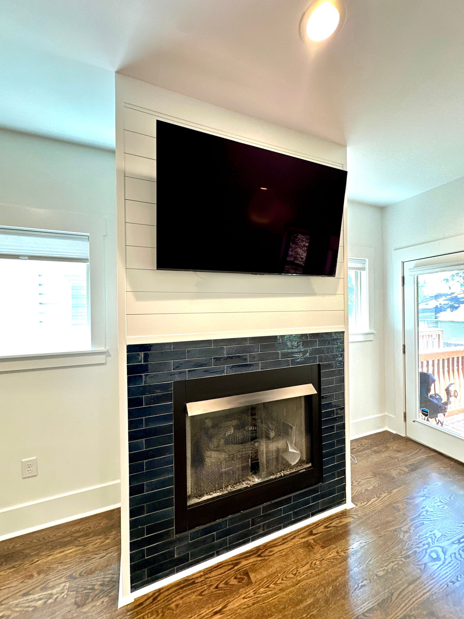 A living room with a fireplace and a flat screen tv above it.