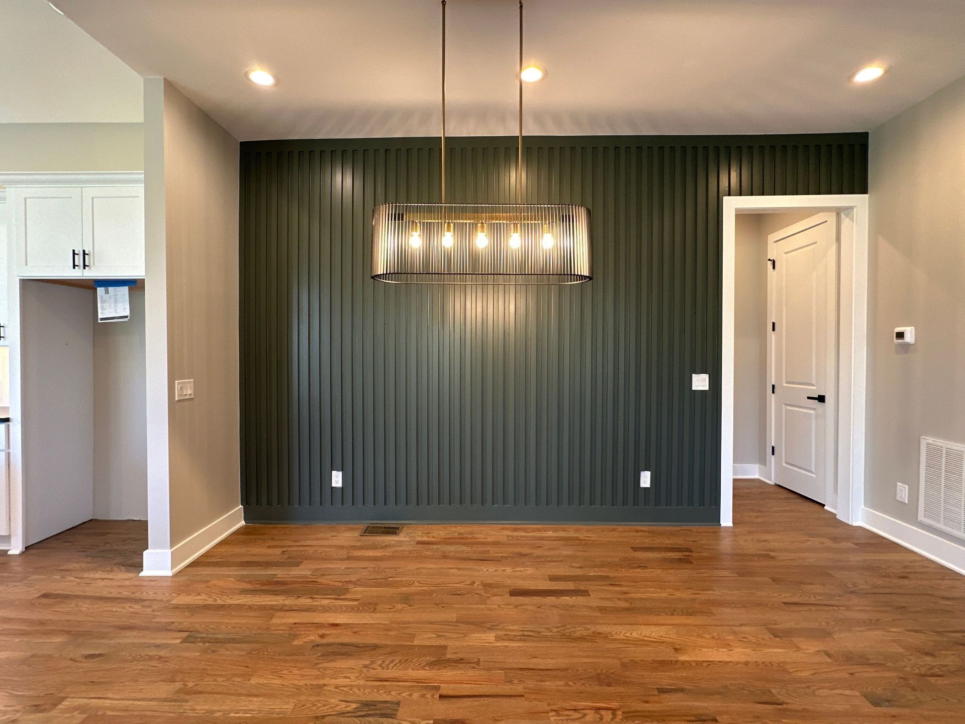 An empty dining room with hardwood floors and a chandelier hanging from the ceiling in Nashville, TN