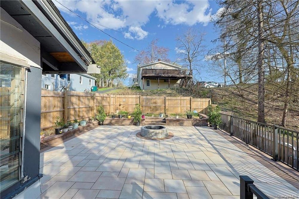 A large white house with a stone walkway leading to it surrounded by trees.