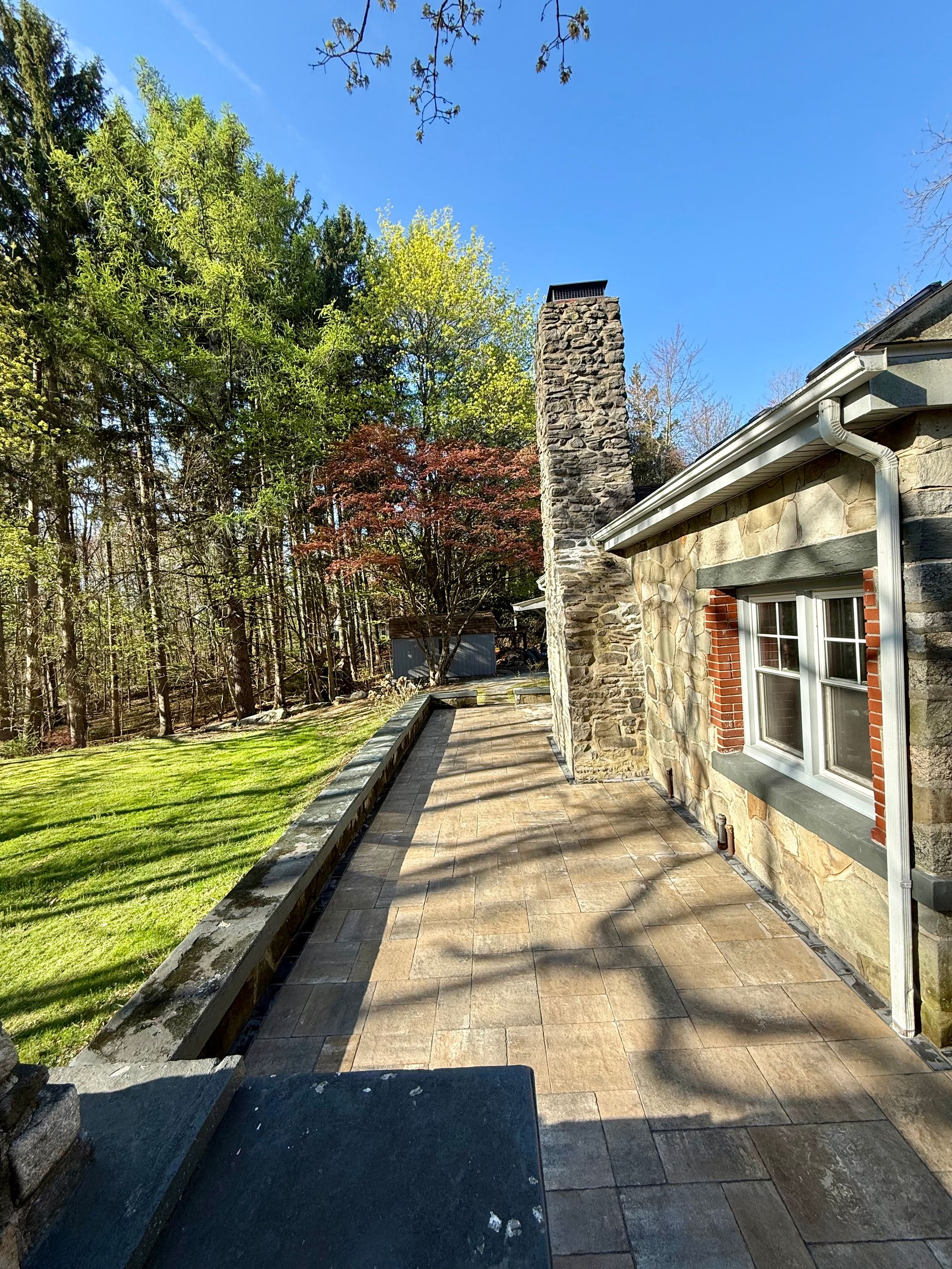 A stone house with a brick walkway leading to it.