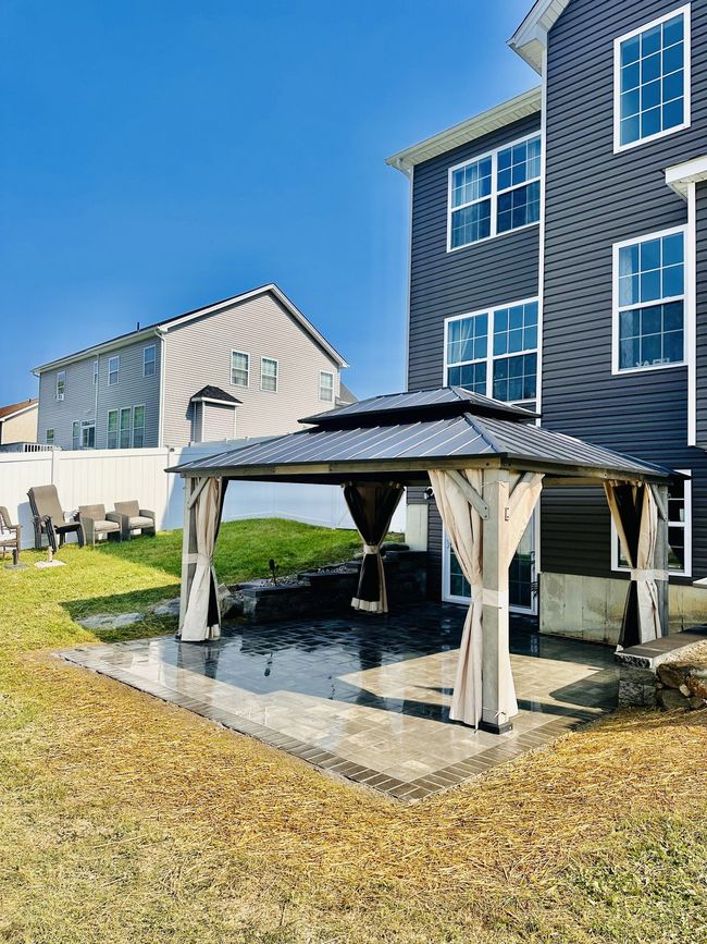 There is a gazebo in the backyard of a house.