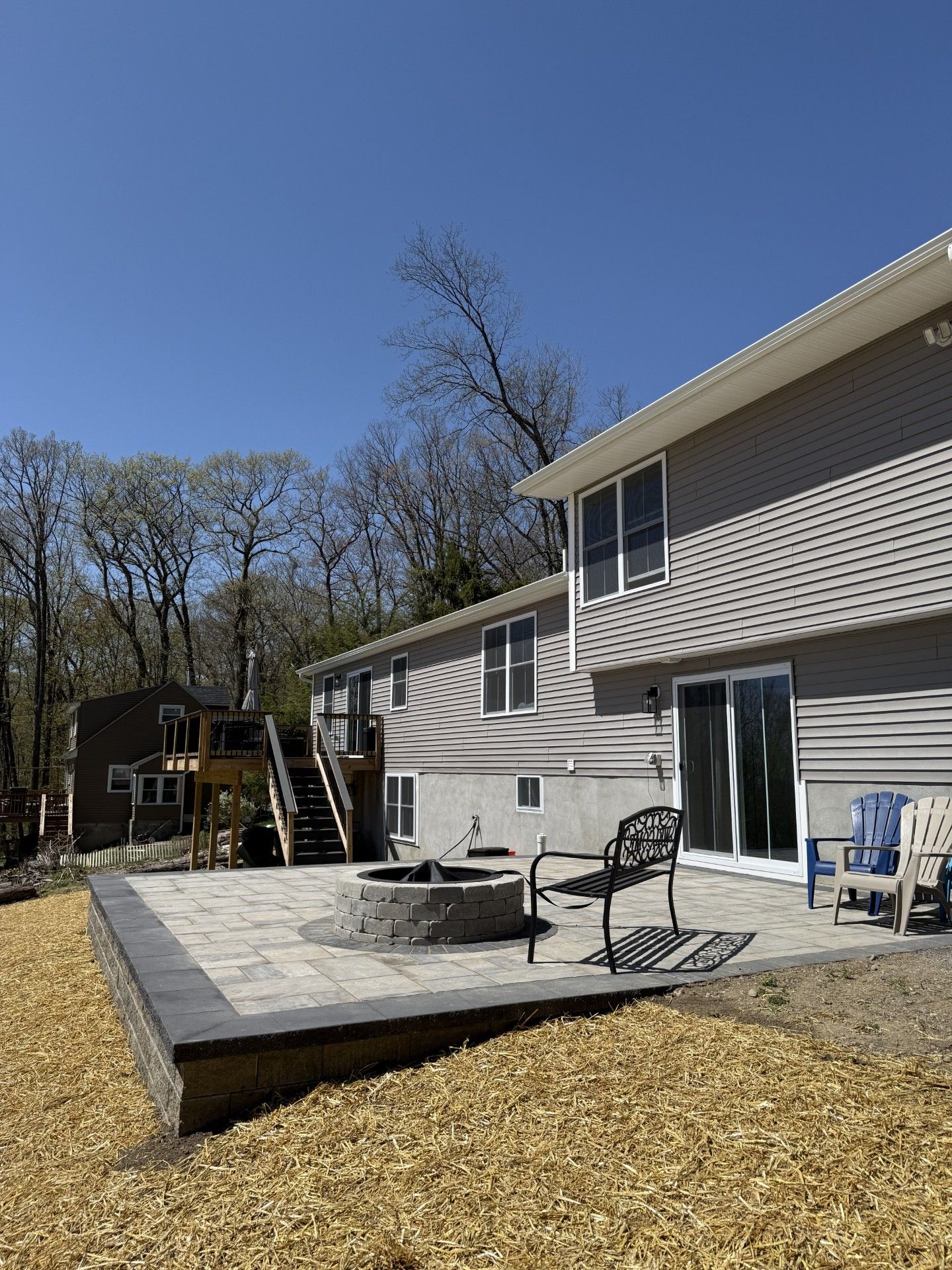 A house with a patio and a fire pit in front of it.
