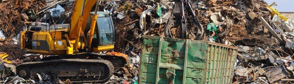 Waste for recycling piled up next to a digger