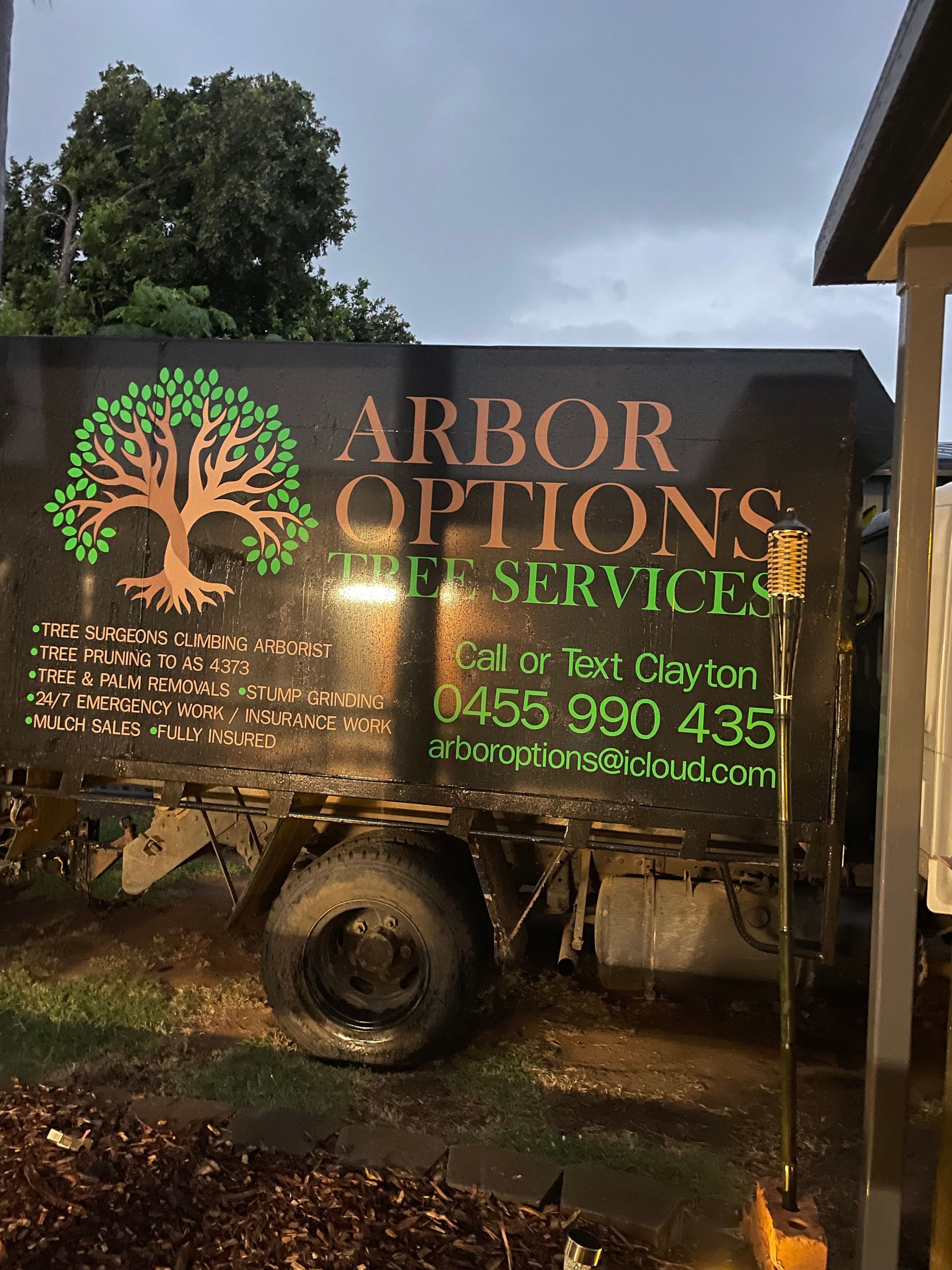 A black trailer for Arbor Options Tree Services featuring a tree logo, contact number 0455 990 435, and text details.