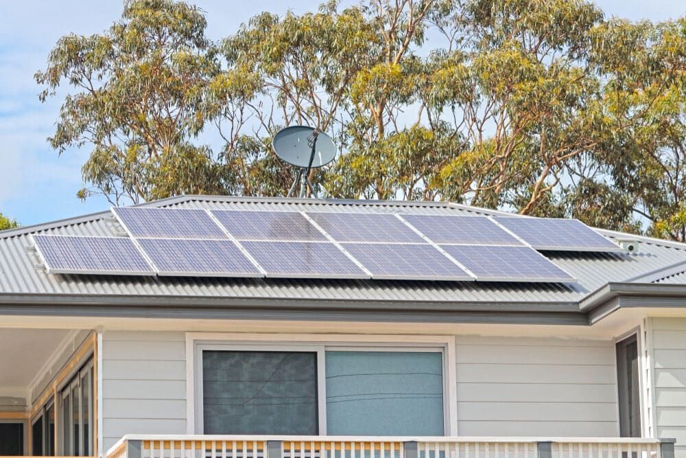 A House With Solar Panels On The Roof And A Satellite Dish — Solarblu Pty Ltd In Wollongong, NSW