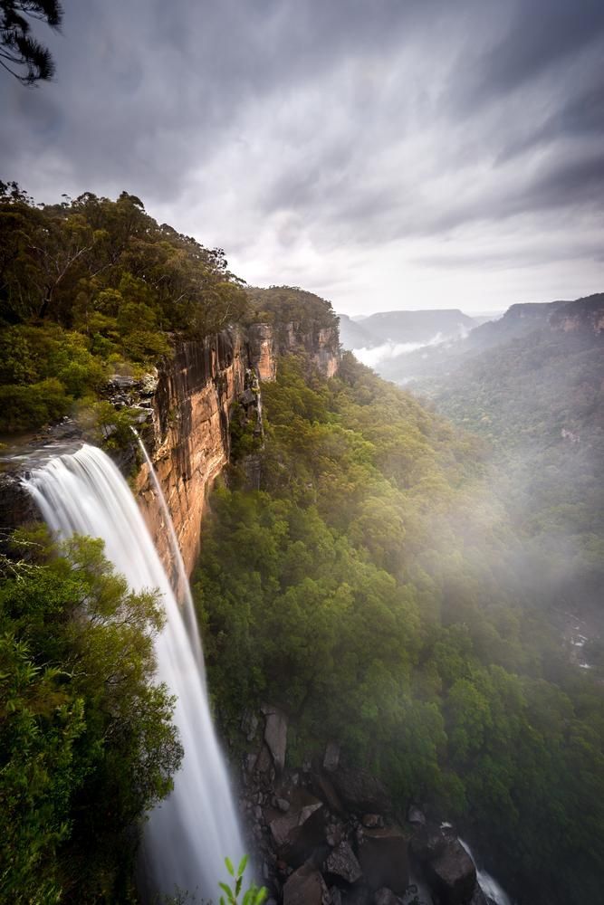 A Waterfall is Surrounded by Trees and Rocks in the Middle of a Forest — Solarblu Pty Ltd in Fitzroy Falls, NSW