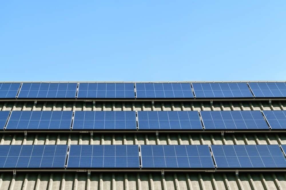 A Row Of Solar Panels On The Roof Of A Building — Solarblu Pty Ltd In Calderwood, NSW
