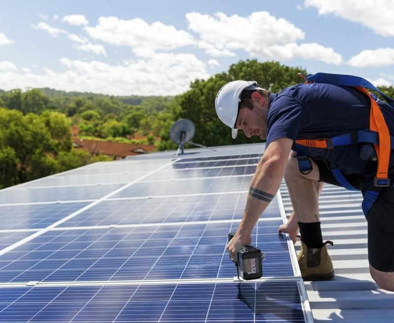 A Man is Installing Solar Panels on a Roof — Solarblu Pty Ltd in Kangaroo Valley, NSW