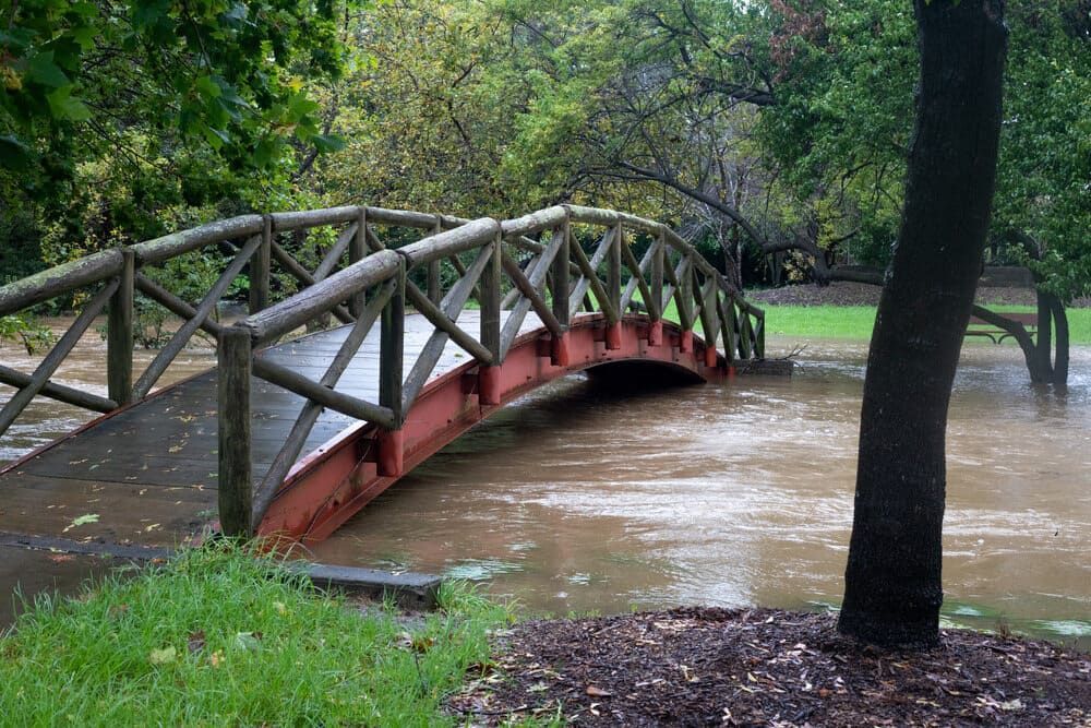 A Wooden Bridge Over A Flooded River In A Park — Solarblu Pty Ltd In Mittagong, NSW
