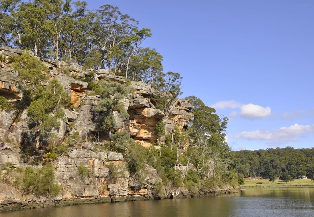 A Cliff Overlooking A Lake With Trees On It — Solarblu Pty Ltd In Nowra, NSW