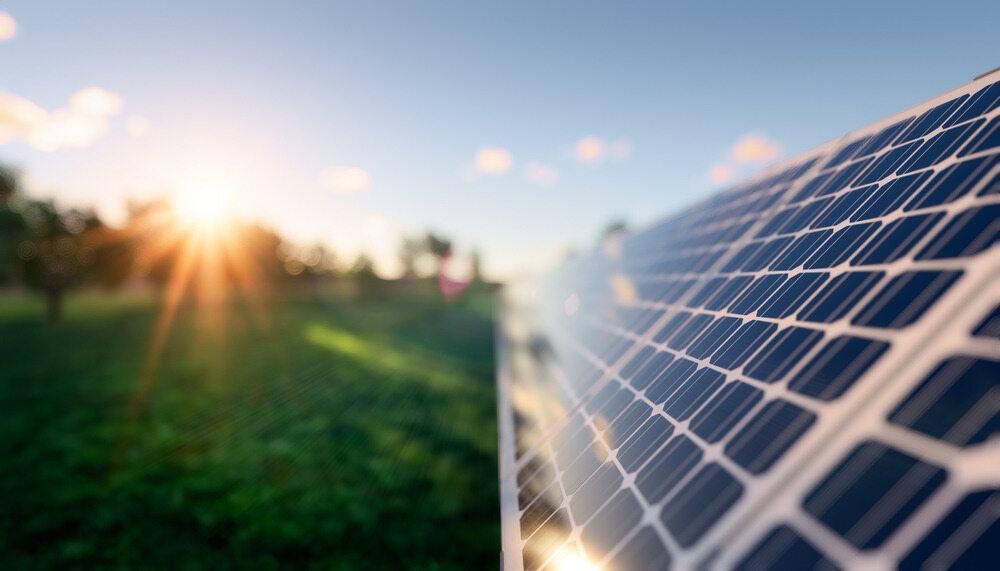 A Close Up Of A Solar Panel In A Field With The Sun Shining Through It — Solarblu Pty Ltd In Tullimbar, NSW