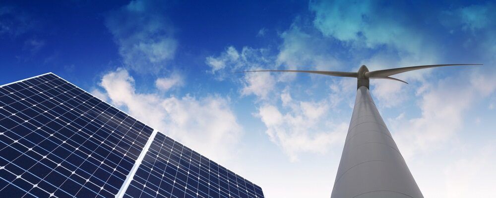 A Wind Turbine And Solar Panels Are Against A Blue Sky — Solarblu Pty Ltd In Bowral, NSW