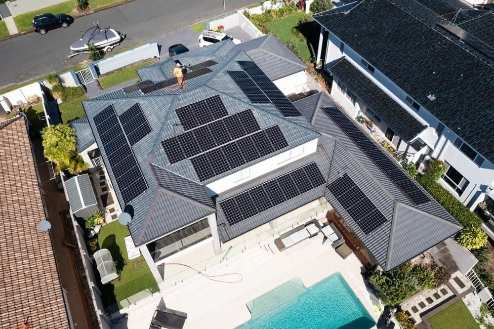 An Aerial View Of A House With Solar Panels On The Roof And A Pool — Solarblu Pty Ltd In Shellharbour, NSW