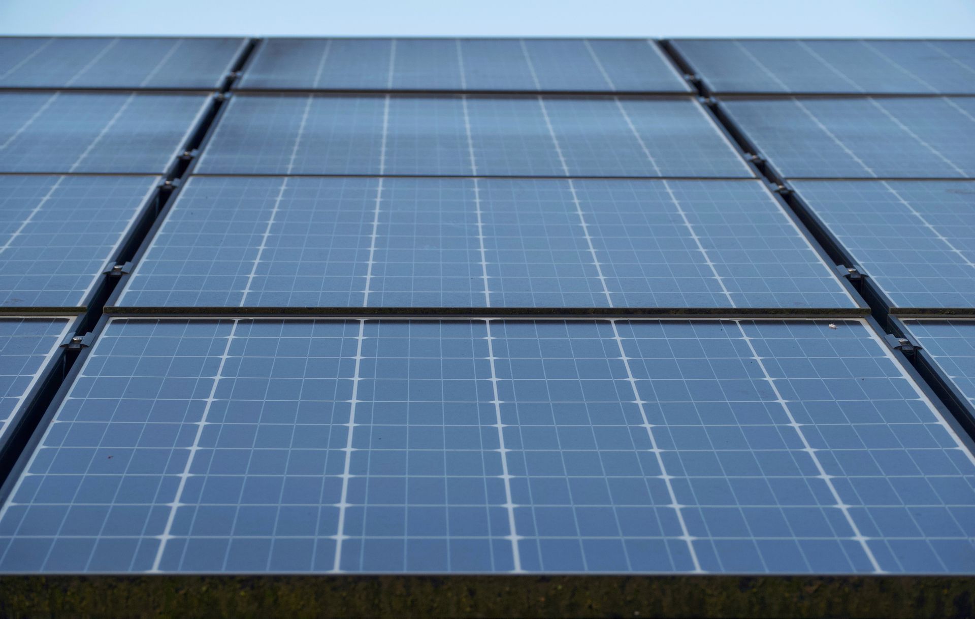 Two Men Are Working On A Solar Panel On Top Of A Building — Solarblu Pty Ltd In Woonona, NSW