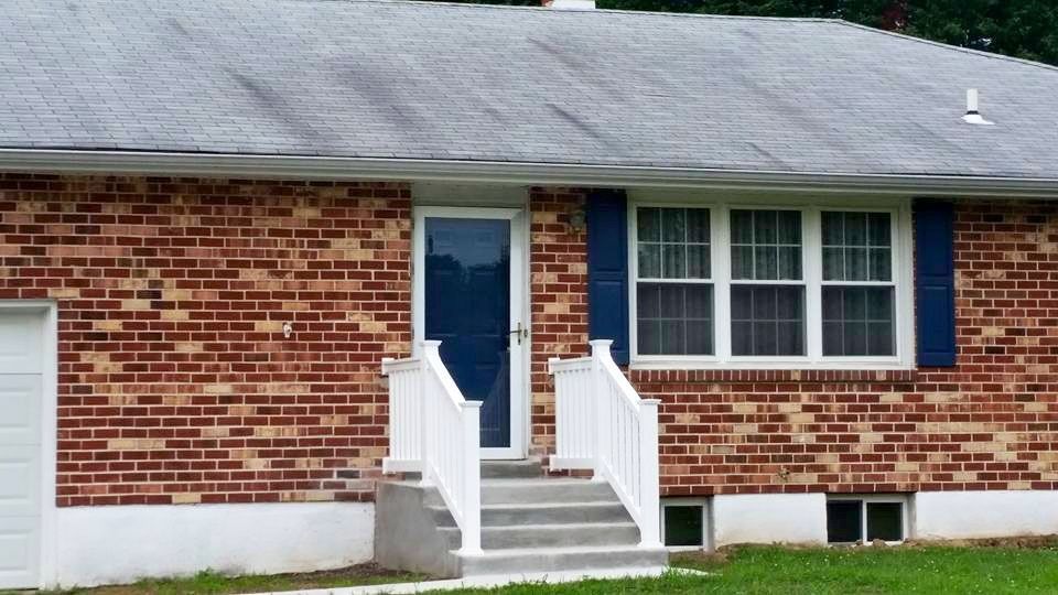 A red brick house with white trim and blue shutters