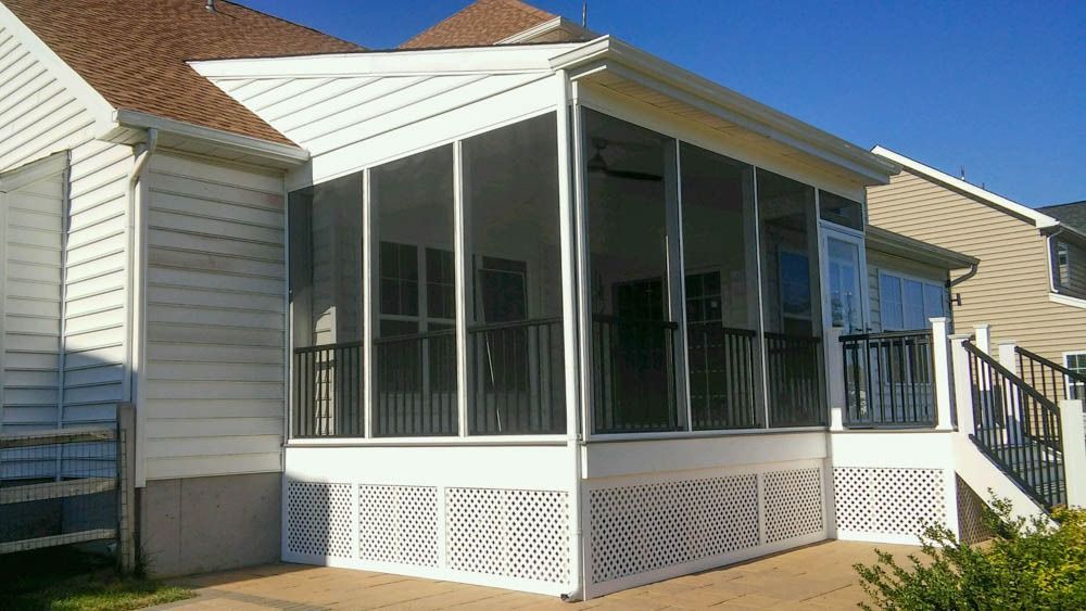 A screened in porch on the side of a house
