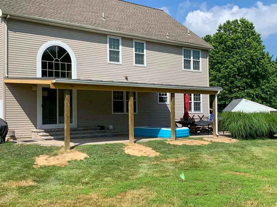 A large house with a covered patio and a pool in the backyard.