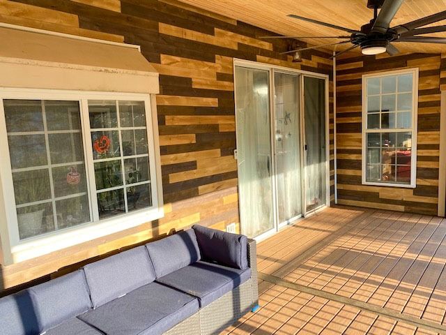 A patio with a couch and a ceiling fan