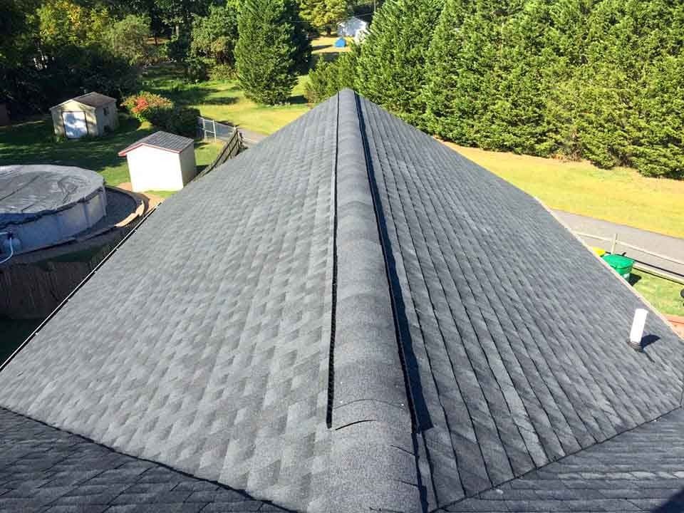 The roof of a house with a pyramid shaped roof.