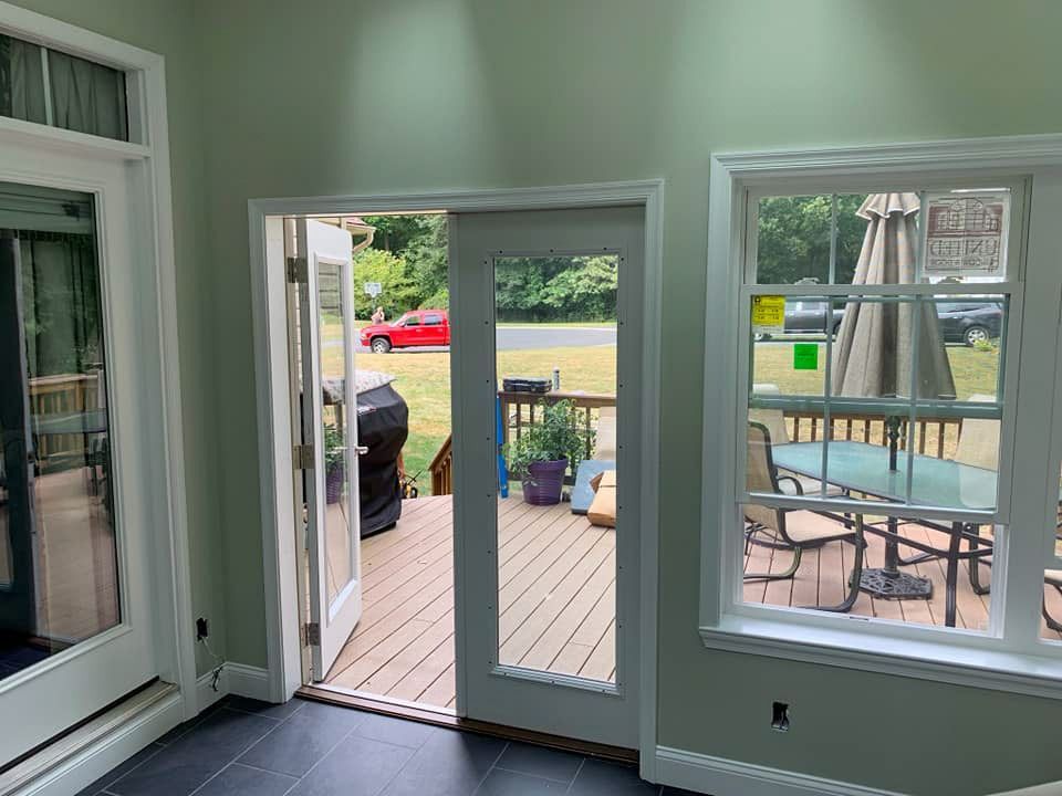 A sun room with sliding glass doors leading to a deck.