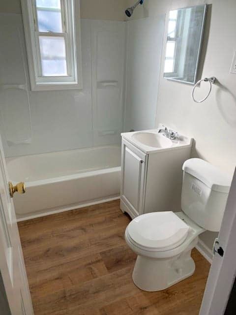A bathroom with a toilet , sink , and bathtub.